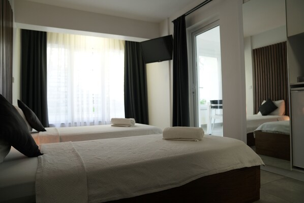 A hotel room with two beds, a flat-screen TV, and a sliding glass door leading to a balcony. - Exen By Weekend Otel (Bodrum)