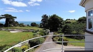 A view from a balcony overlooking a landscaped garden with a pathway leading to a body of water. - Westdale Edge (Seaton)