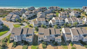 Una zona residenziale costiera con diversi edifici a due piani, dotati di balconi e vista sull'oceano.