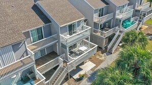 Un edificio residenziale a più piani con balconi, piscina e prato curato.
