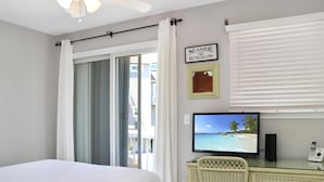 A bedroom with a bed, a desk with a computer, a chair, a window with curtains, and a sign that reads "SEASIDE BUNGALOW". - Barrier Dunes 426 - 62 Beach House Too (Port St. Joe)