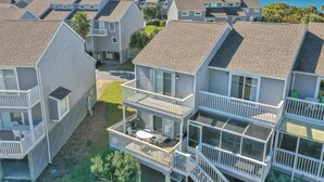 A residential complex with multiple two-story houses featuring balconies, a small courtyard, and a view of the ocean. - Barrier Dunes 426 - 62 Beach House Too (Port St. Joe)