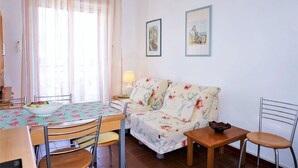 Un espace repas comprenant une table, des chaises, un canapé et une lampe.