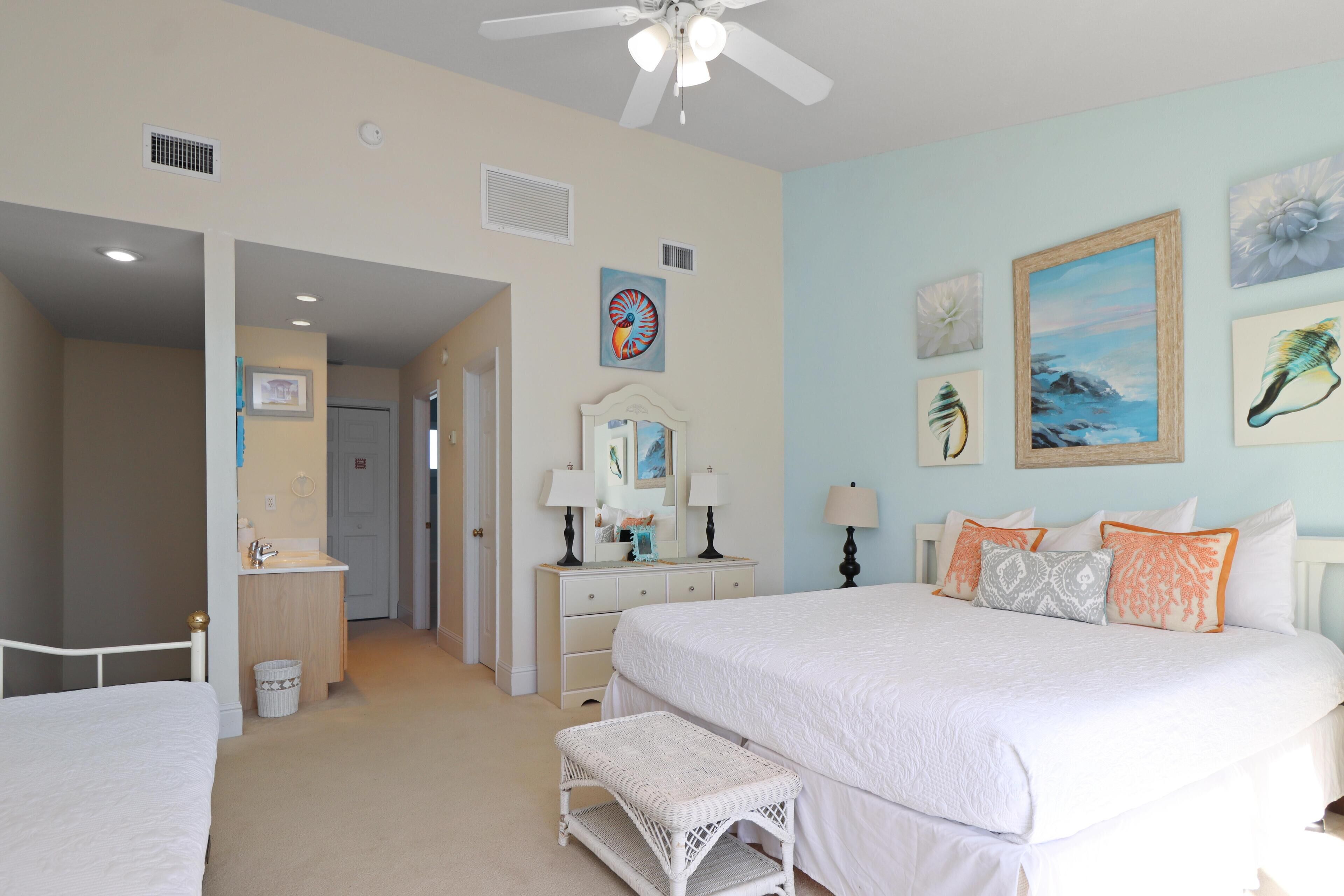 A bedroom with a bed, a bench, a dresser, and a mirror.