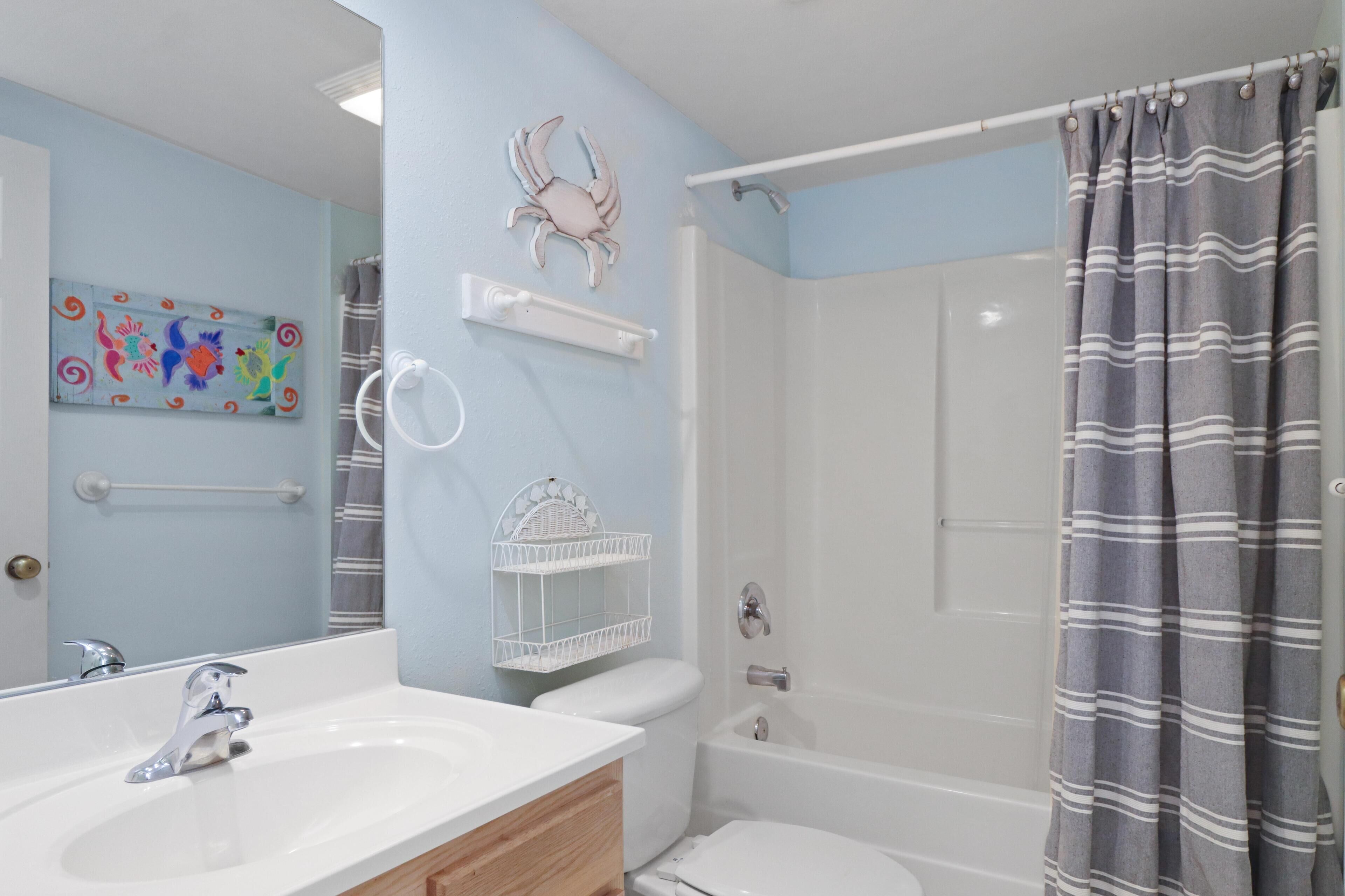 Un baño con lavamanos blanco, inodoro y ducha.