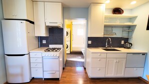 Una cocina compacta con electrodomésticos blancos, lavadora y lavaplatos.