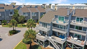 A multi-story residential building with balconies, a parking lot, and palm trees. - Barrier Dunes 497 - 33 (Port St. Joe)