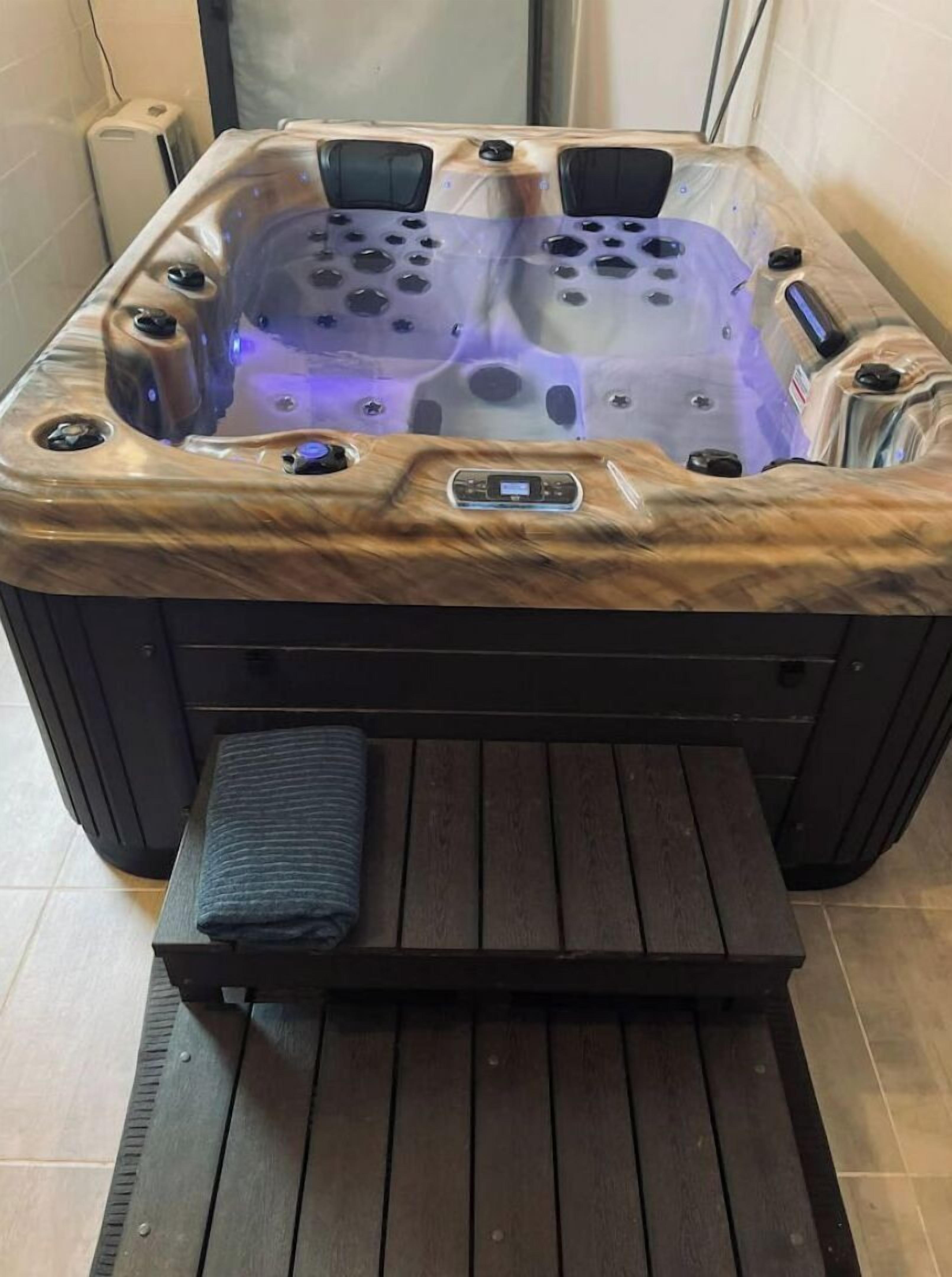 Un jacuzzi con revestimiento de madera y panel de control lateral.