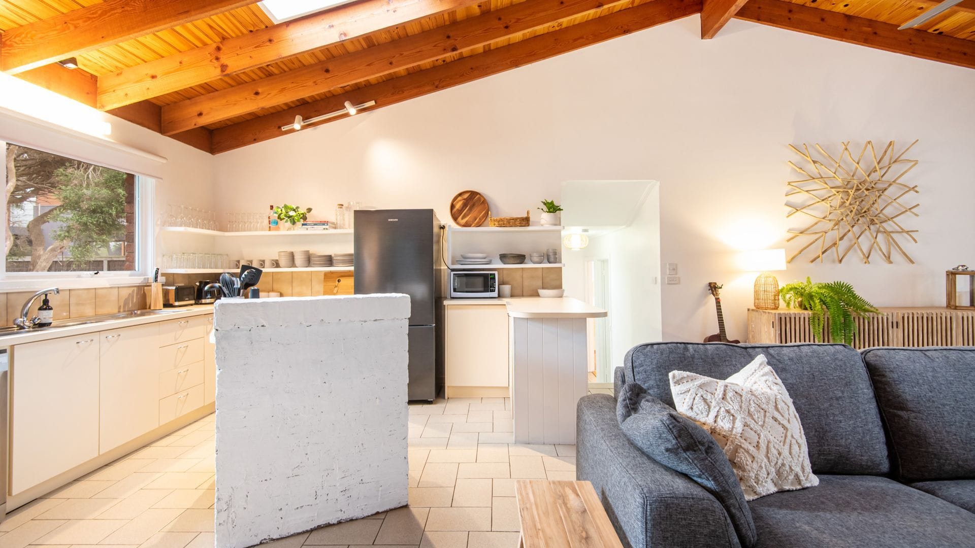 A modern kitchen with a refrigerator, microwave, and wooden cabinets.