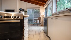 A kitchen with a built-in oven, a dishwasher, and a window with blinds. - Caxton and Co. Blairgowrie (Blairgowrie)