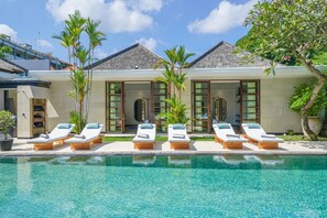 A poolside area with lounge chairs and a clear pool.
