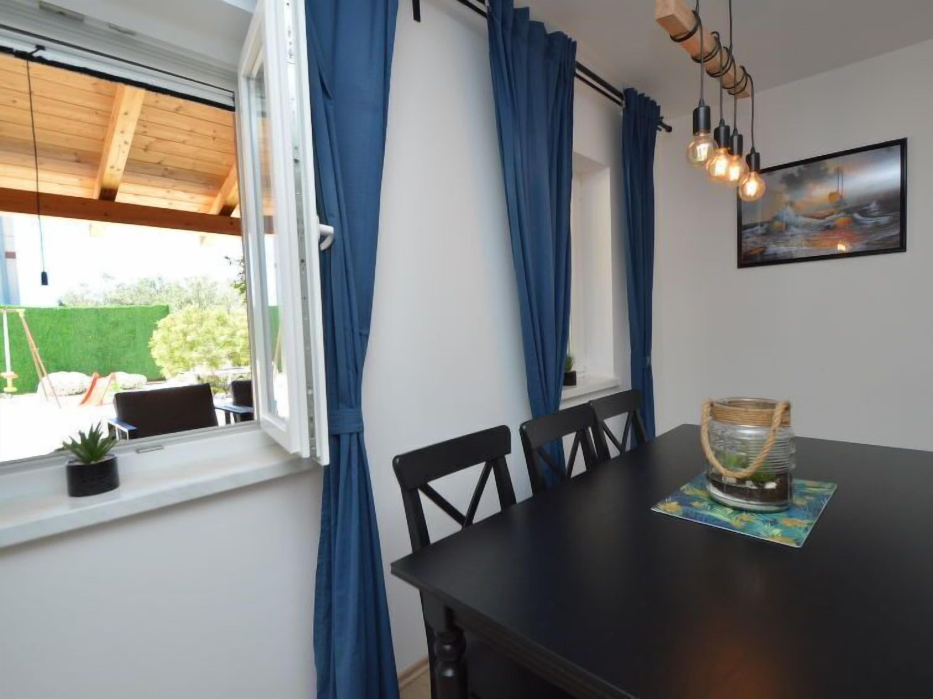A dining area with a table, chairs, and a view of the outdoors.