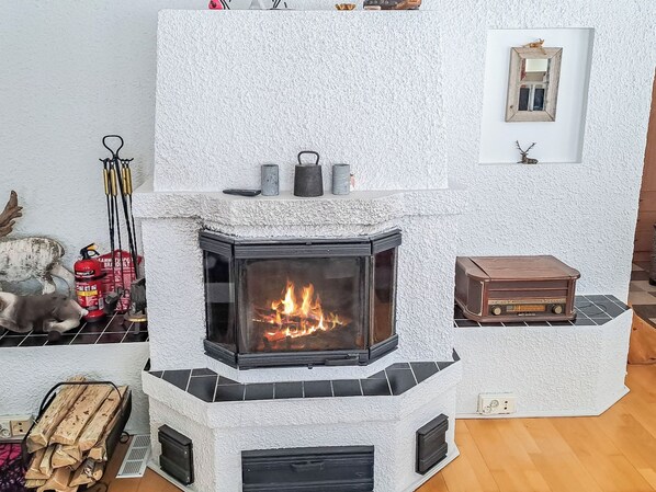 Une cheminée au design moderne, une petite table et un objet décoratif accroché au mur.