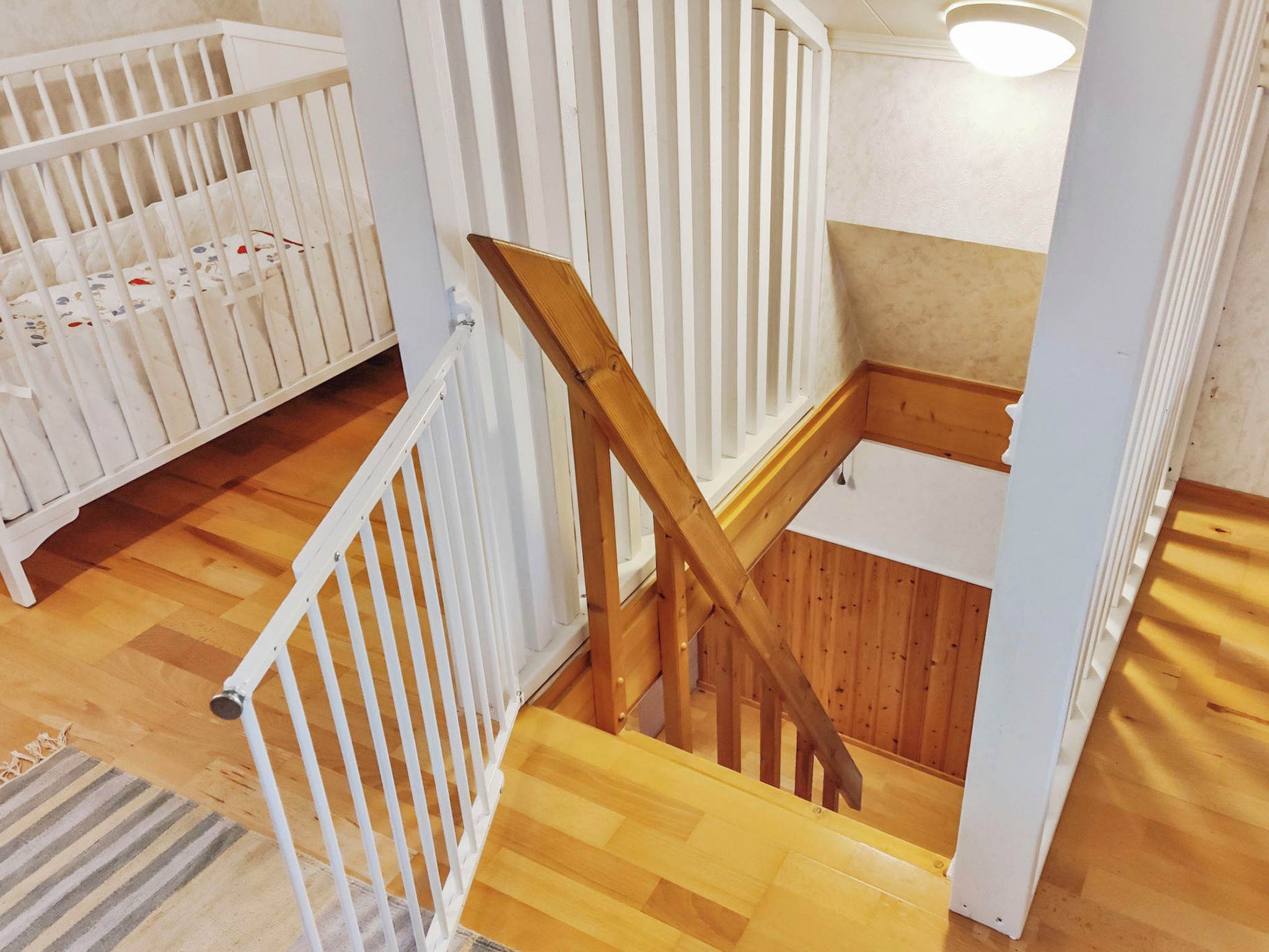 A wooden staircase with white railings leading to a landing.