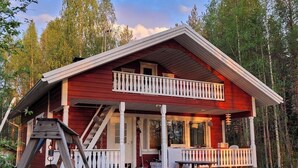A red cabin with a balcony, surrounded by a forest. - Koivulahden reinola by Interhome (Ylitornio)