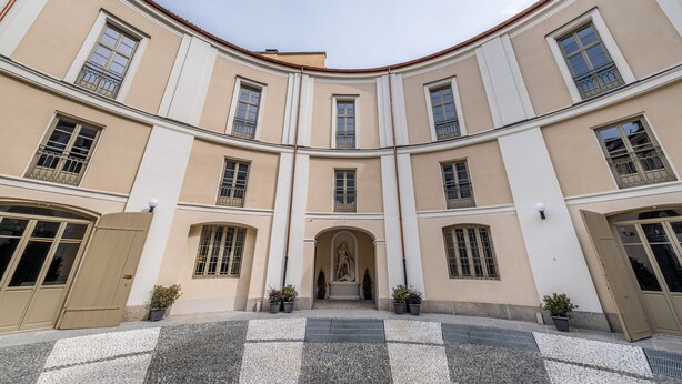 A building with a symmetrical facade, large windows, and a central entrance with a statue. - Oriana Homèl Torino (Turin)