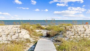 A wooden boardwalk leading to a beach with sand dunes and sparse vegetation. - Gulffront w/ Screened Porch | Dogs Allowed (Indian Pass)