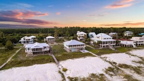 A coastal resort with multiple beachfront villas, each featuring a large balcony and a covered outdoor area. - Gulffront w/ Screened Porch | Dogs Allowed (Indian Pass)