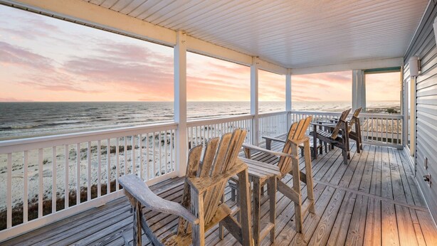 A wooden deck with chairs overlooking the ocean at sunset. - Gulf-Front Estate with Private Pool (Indian Pass)