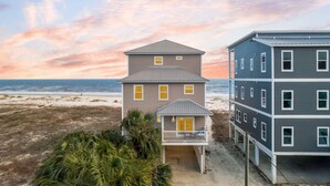 A beachfront property with a two-story house featuring a balcony and a separate garage. - Gulf-Front Estate with Private Pool (Indian Pass)