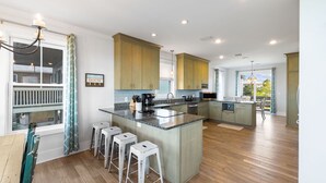 Una cocina amplia con una isla central, armarios de madera y vistas al exterior.