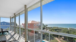 Ein Balkon mit Blick auf den Ozean und einen Poolbereich.