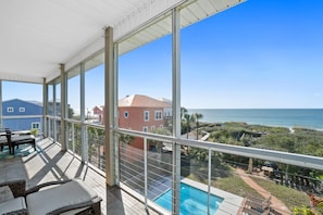 Un balcon avec vue sur l’océan et un espace piscine.