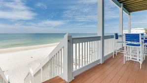 A beach view from a wooden deck with white railings and blue chairs. - Family Beach Escape Near Gulf and Bay (Cape San Blas)
