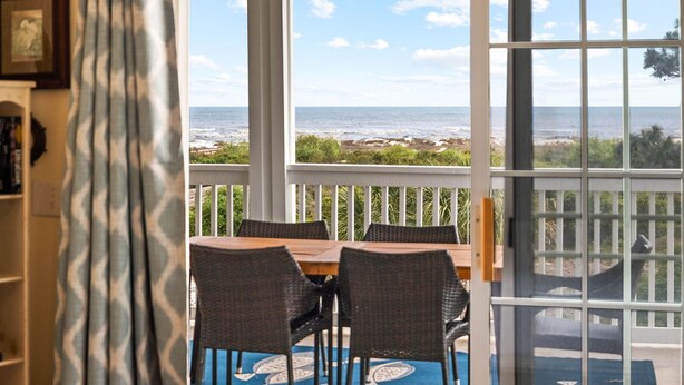 A covered patio with a view of the ocean, wicker furniture, and a blue patterned rug. - Gulffront | Pool Access |  Salinas Park (Cape San Blas)