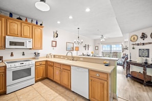 A modern kitchen with wooden cabinets, a built-in microwave, and a dishwasher.