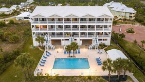 A multi-story hotel with a swimming pool and outdoor seating area. - Gulffront | Pool Access |  Salinas Park (Cape San Blas)