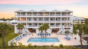 A multi-story hotel with a pool area, balconies, and a view of the surrounding landscape. - Gulffront | Pool Access |  Salinas Park (Cape San Blas)