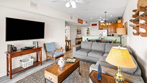 A living room with a flat-screen TV, wooden coffee table, and a patterned rug. - Gulffront | Pool Access |  Salinas Park (Cape San Blas)