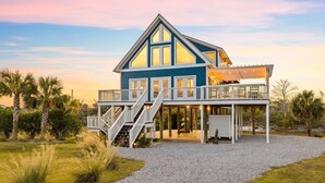 Een twee verdiepingen tellend huis met een balkon en een overdekt terras.