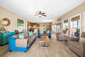 A spacious living room with a central coffee table, two sofas, and a dining area with a table and chairs.