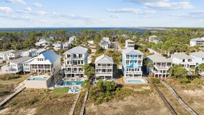 A coastal residential area with multiple two-story houses, some with balconies and a small pool area.