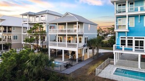 A multi-story residential building with balconies, a swimming pool, and a well-maintained garden.