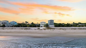 Una propiedad frente a la playa con varios edificios, una playa de arena y olas del océano.