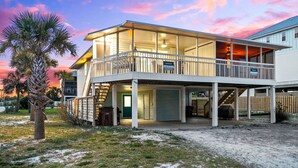 A two-story beachfront property with a balcony and a covered area. - Cozy Duplex Near Community Beach Access (Port St. Joe)