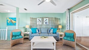 A living room with a sofa, two armchairs, a coffee table, and a ceiling fan. - Cozy Duplex Near Community Beach Access (Port St. Joe)