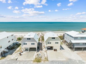 A beachfront property with multiple houses, a sandy beach, and the ocean in the background. - Gulf Views | Dogs Allowed | Steps to Beach (Port St. Joe)
