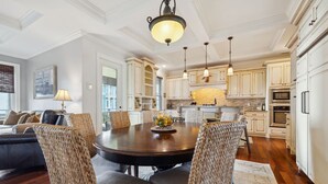 A spacious kitchen with white cabinetry, a central island, and pendant lighting.