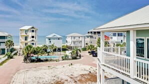 A beachfront property with multiple buildings, a swimming pool, and a sandy beach. - Beach Retreat w/Pool and Foosball (Port St. Joe)
