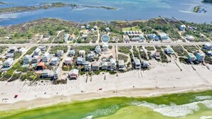 An aerial view of a coastal residential area with houses, a beach, and a clear view of the ocean. - Beach Retreat w/Pool and Foosball (Port St. Joe)