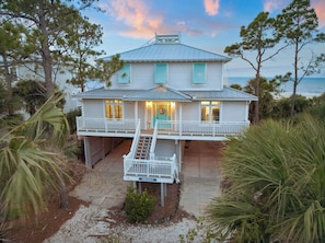 A two-story house with a balcony, a staircase leading to the upper level, and a view of the ocean. - Beachfront with Private Boarkwalk to Beach (Indian Pass)