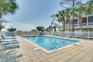 A rectangular pool with blue water, surrounded by a white fence and palm trees. - Beachfront with Private Boarkwalk to Beach (Indian Pass)
