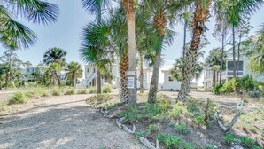 A paved pathway lined with palm trees and a sign indicating a private driveway.