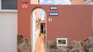 A narrow stone-walled corridor leading to a door marked 'VV' and 'CASA MATYAS' signs. - Holiday Home Casa Matyas close to the Beach with Garden & Wi-Fi (Icod de los vinos)