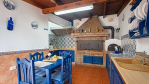 A kitchen with blue chairs, a wooden table, a brick oven, and blue cabinets. - Holiday Home Casa Matyas close to the Beach with Garden & Wi-Fi (Icod de los vinos)