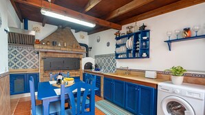 A kitchen with blue cabinets, a wooden ceiling, a built-in oven, and a washing machine. - Holiday Home Casa Matyas close to the Beach with Garden & Wi-Fi (Icod de los vinos)
